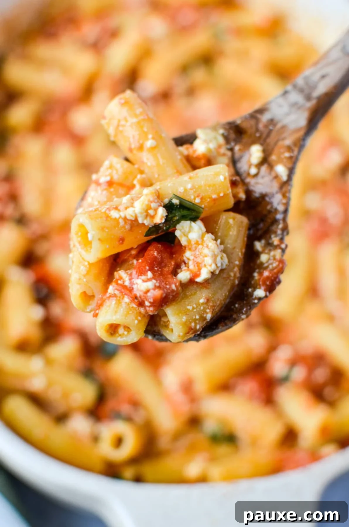 Roasted Tomato and Feta Pasta 9 A spoonful of cooked pasta mixed with roasted cherry tomatoes and crumbled feta cheese, ready to eat.