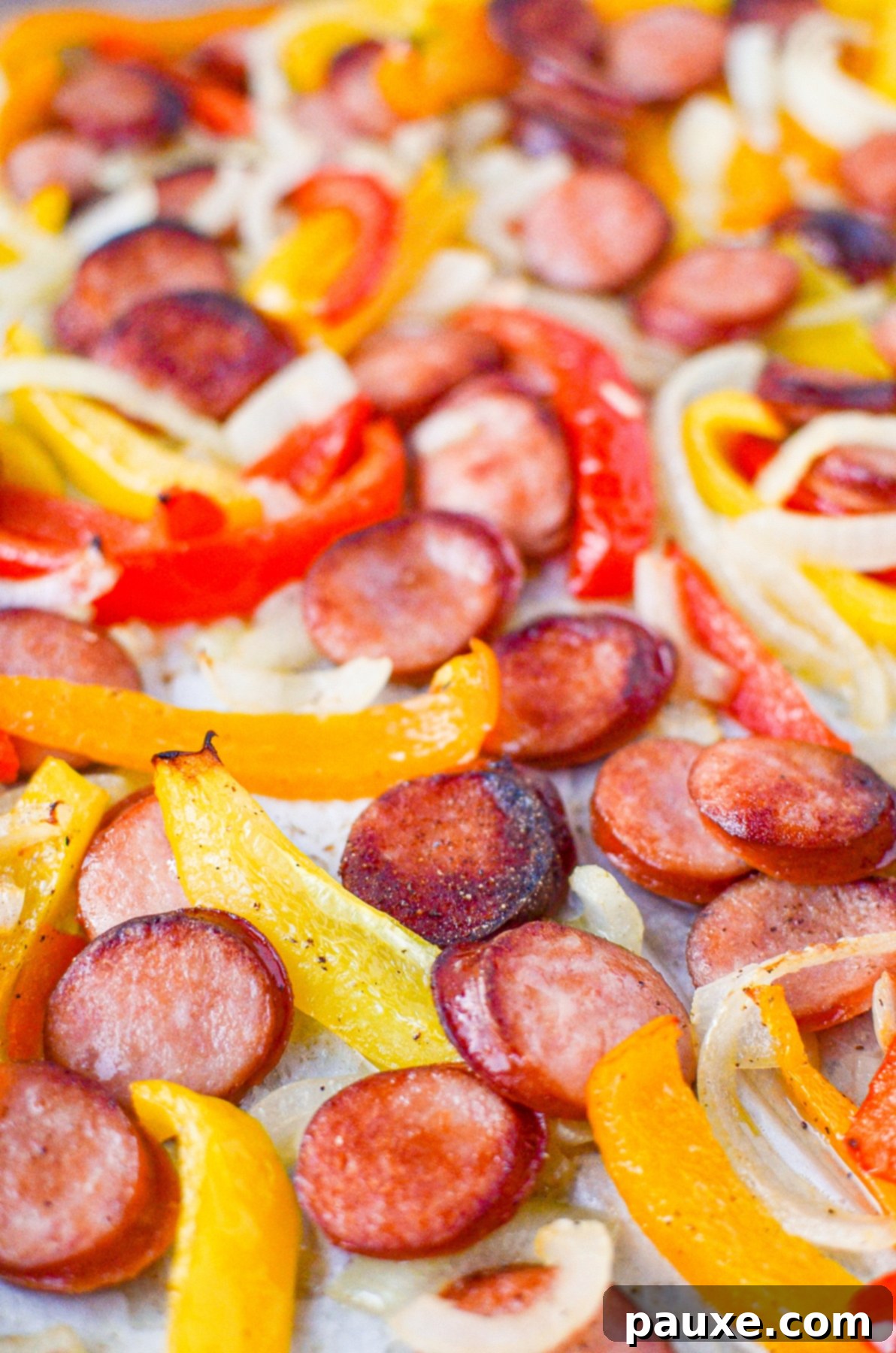 One-Pan Smoked Sausage and Peppers Feast 8 A vibrant close-up of beautifully browned smoked sausage slices, tender bell peppers, and caramelized onions on a sheet pan, showcasing the delicious texture.