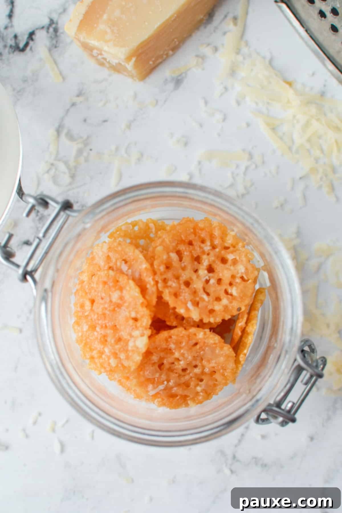 Crispy Parmesan Bites 2 A small glass jar brimming with golden, crunchy homemade Parmesan Crisps, perfect for a healthy snack.