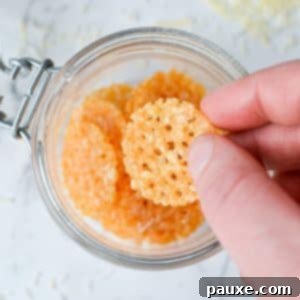 Crispy Parmesan Bites 11 A clear glass jar filled with an abundance of perfectly golden, round Parmesan Crisps, ready for snacking.