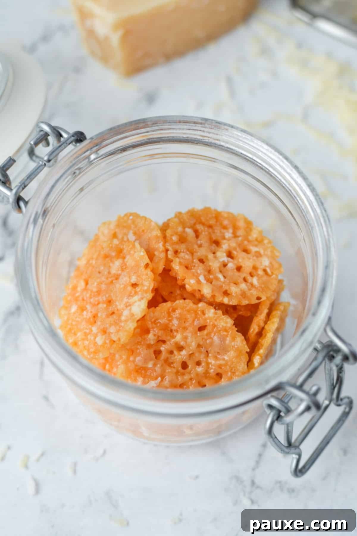 Crispy Parmesan Bites 7 A clear glass jar filled with an abundance of perfectly golden, round Parmesan Crisps, ready for snacking.