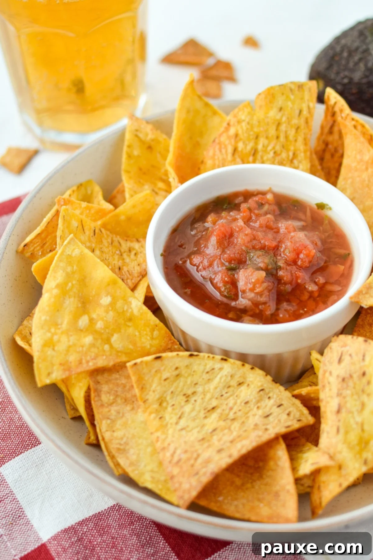 A bowl of tortilla chips with salsa in the middle.