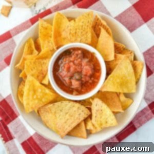 A bowl of tortilla chips with salsa in the middle.