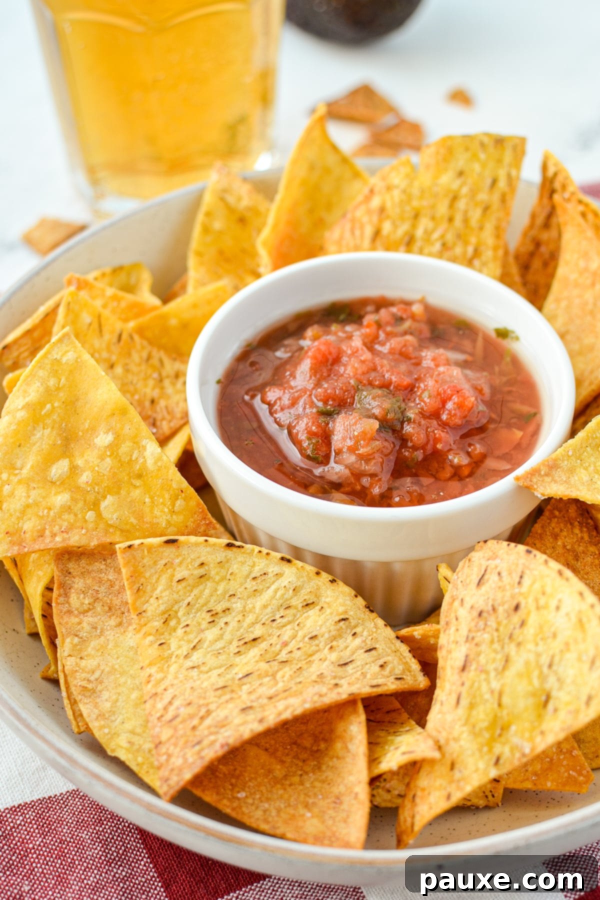 A bowl of tortilla chips with salsa in the middle.