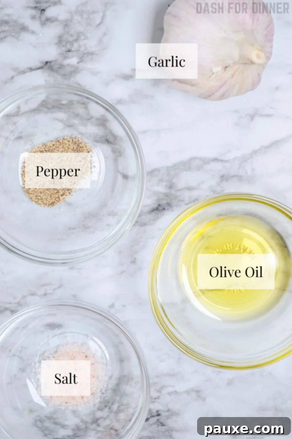 Perfect Air Fryer Roasted Garlic 3 A collection of ingredients laid out on a wooden board, including a bulb of garlic, a bottle of olive oil, and small bowls of salt and pepper, all ready to be used for making roasted garlic.
