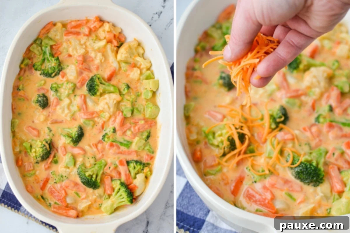 Golden Garden Gratin 5 A casserole dish filled with a creamy vegetable mixture, topped generously with a sprinkle of shredded cheese, ready for baking.