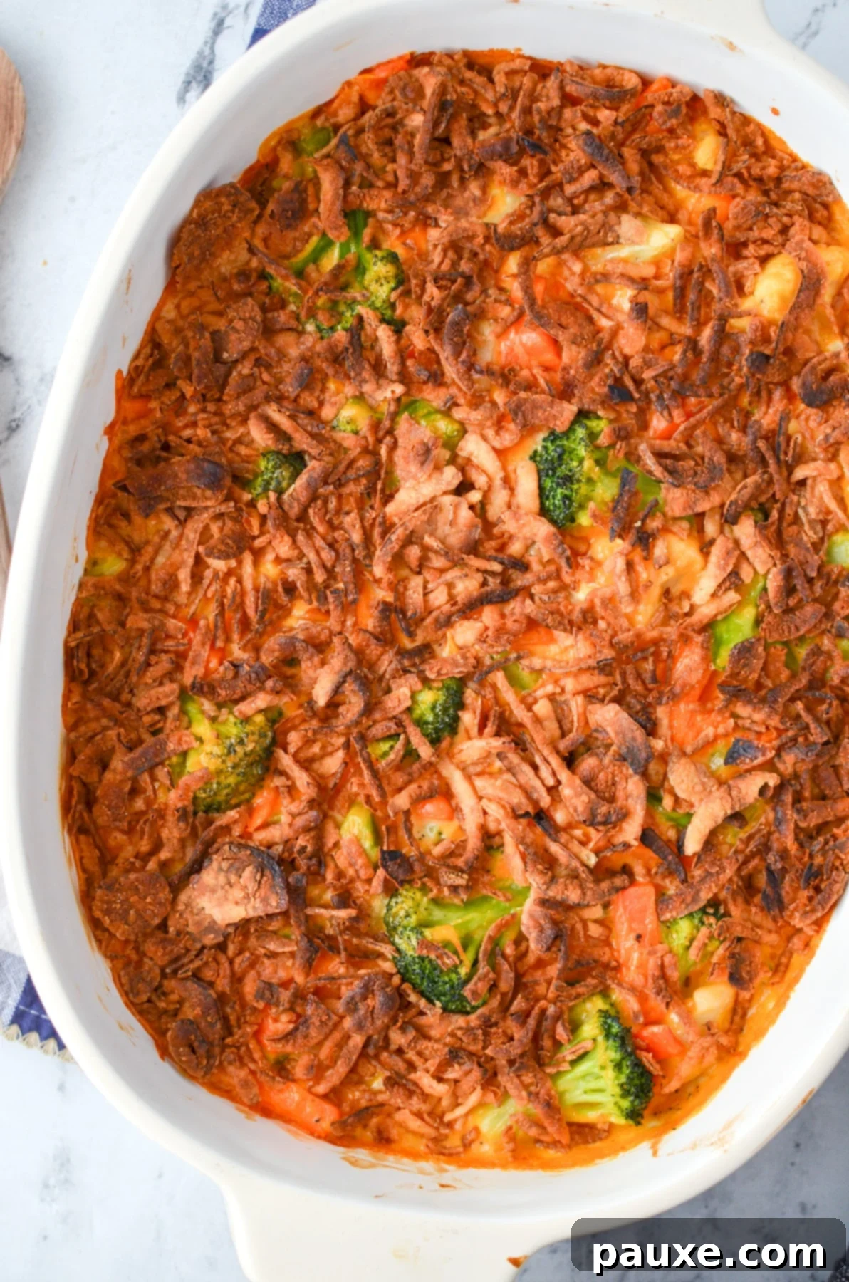 Golden Garden Gratin 7 A finished cheesy vegetable casserole, beautifully golden and topped with a generous layer of crispy fried onions, ready to be served.