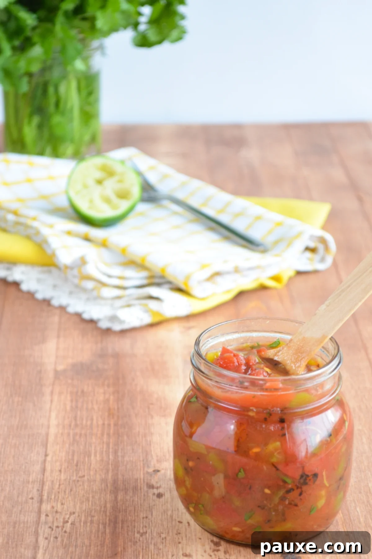 Homemade Rotel-Style Tomatoes and Green Chilies 3 A glass jar filled with vibrant homemade green chilies and diced tomatoes.
