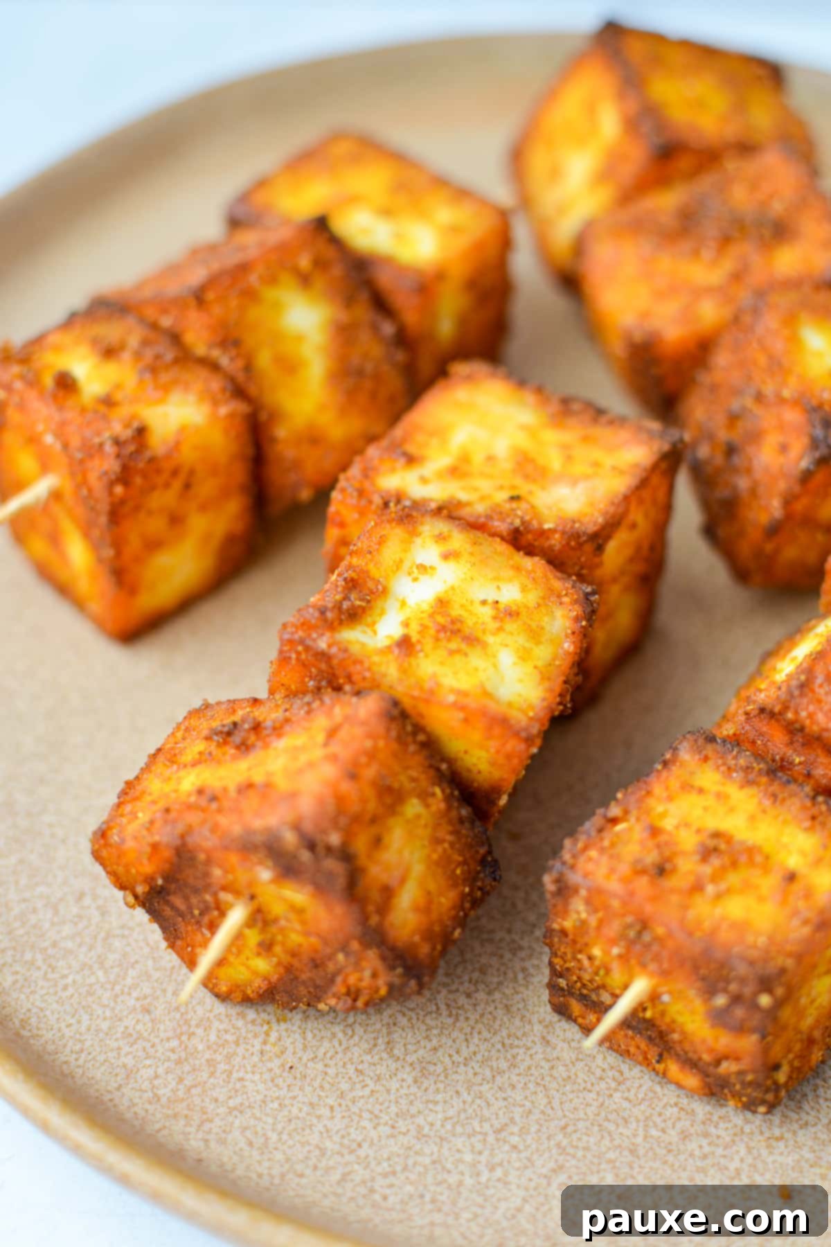 Crispy paneer cubes artfully skewered onto toothpicks, ready for serving.