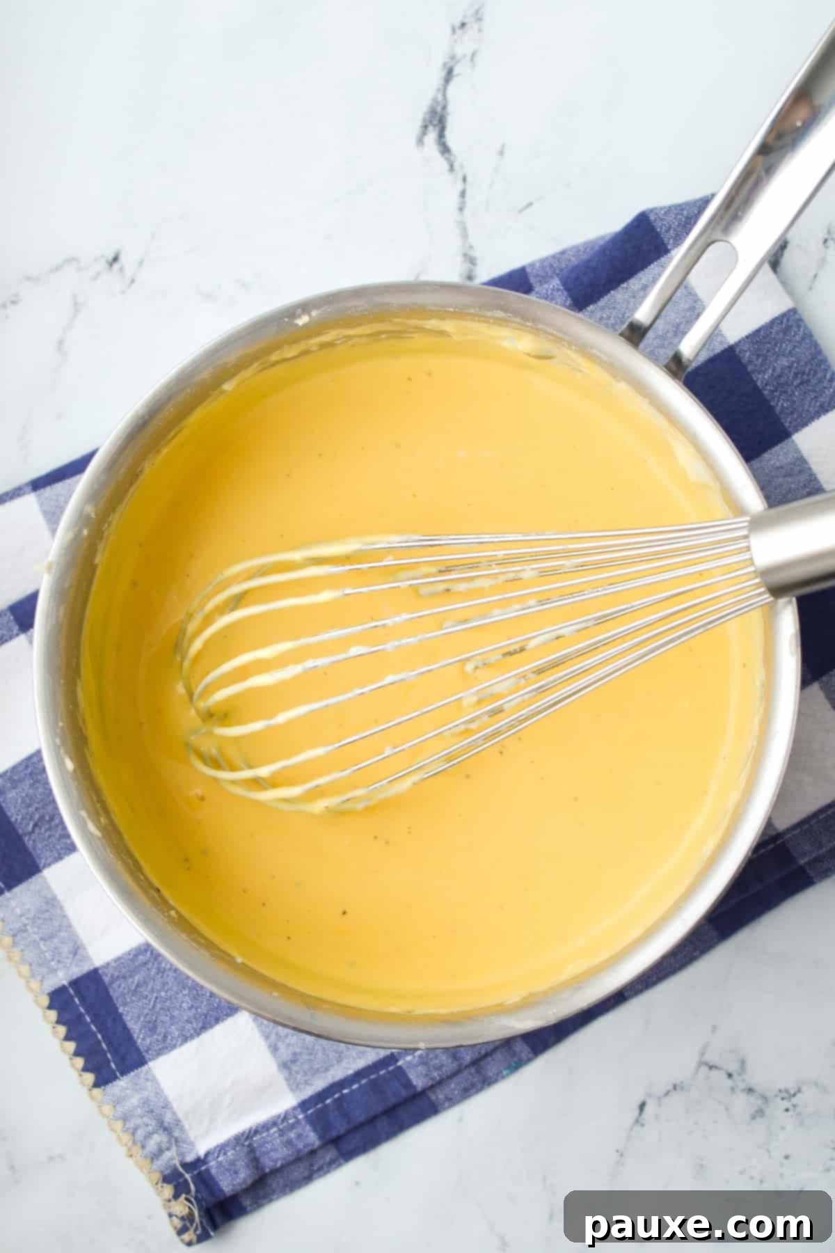Mom's Legendary Cheese Sauce 8 A saucepan filled with a perfectly smooth, golden homemade cheese sauce, ready to be served.