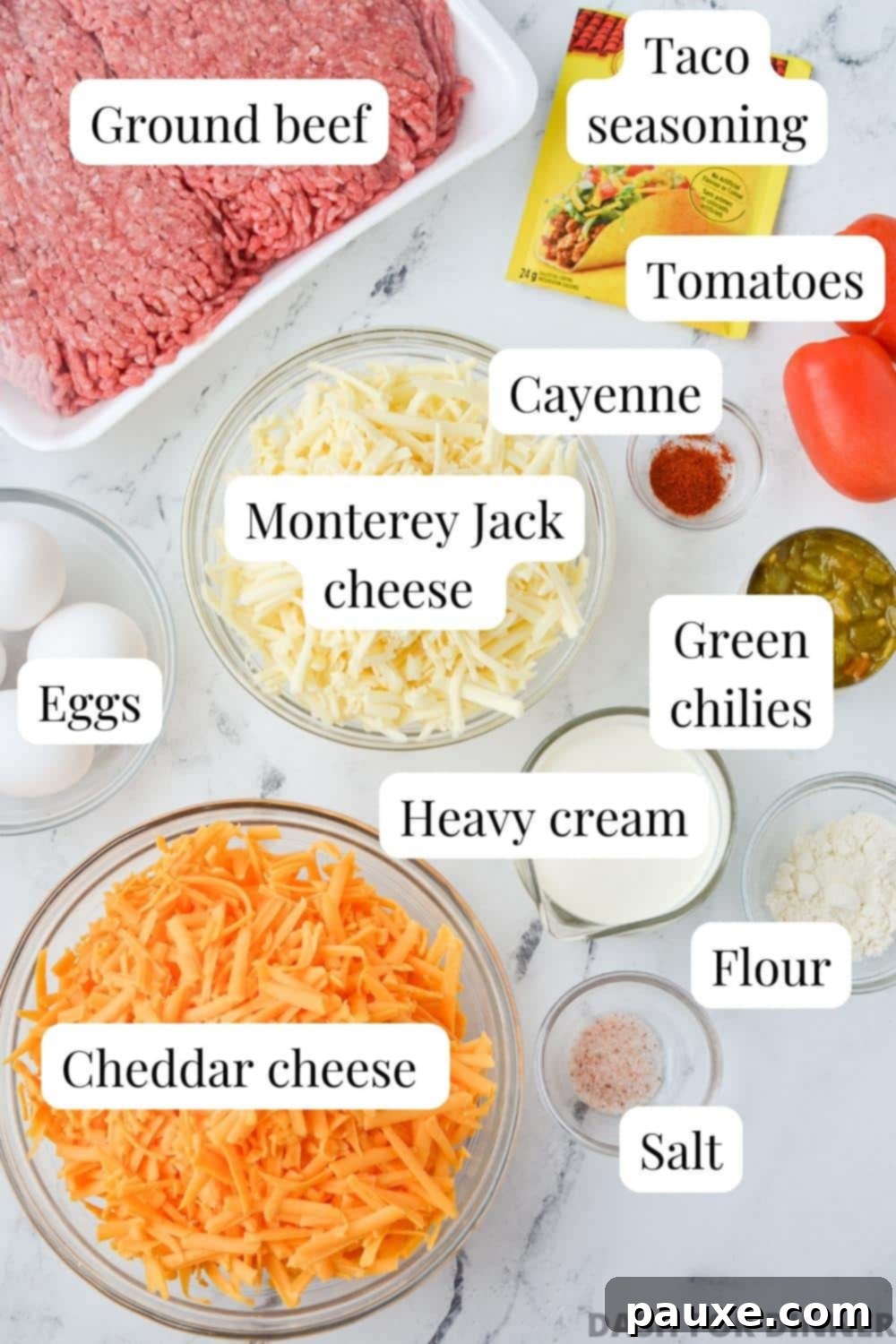 The Duke's Hearty Casserole 4 A collection of fresh ingredients laid out for making the cheesy taco casserole, including ground beef, blocks of cheese, taco seasoning, and vibrant tomatoes.