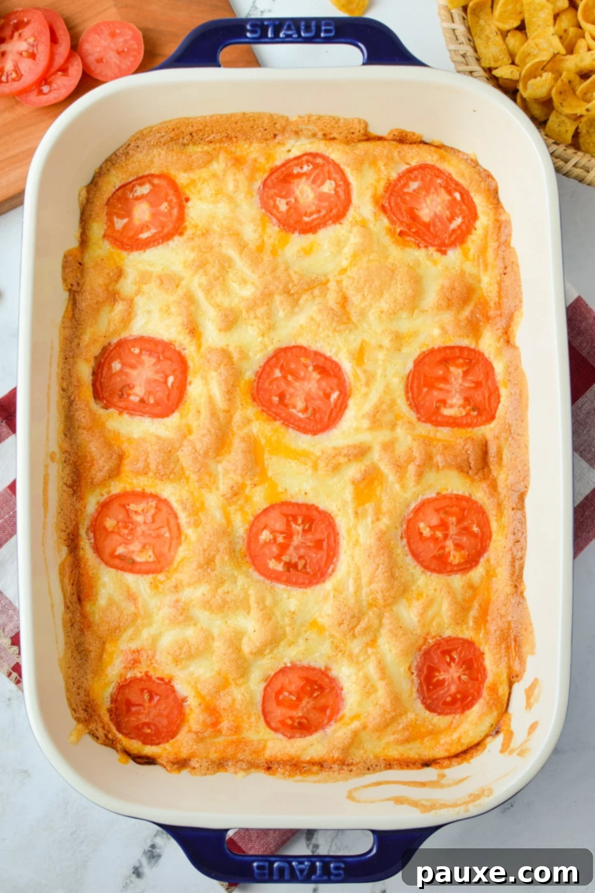 The Duke's Hearty Casserole 8 A perfectly baked John Wayne Casserole, golden and bubbly, fresh from the oven, with tomato slices adding a vibrant touch.