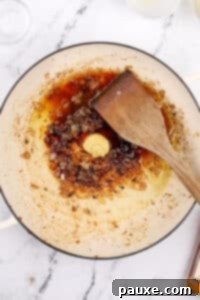 Adding dijon, brandy, and lemon juice to a skillet to make a pan sauce.