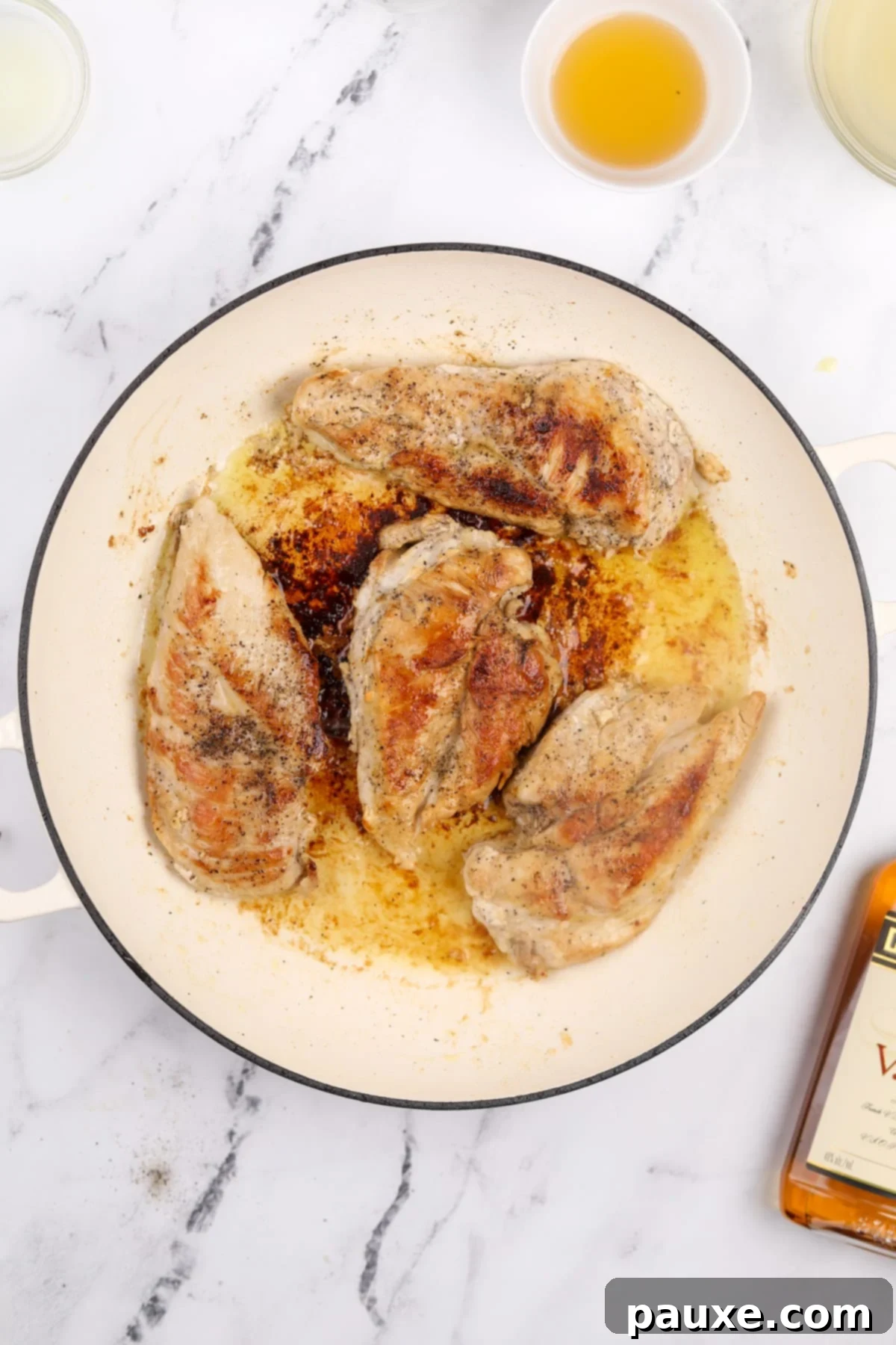 Perfectly browned chicken breasts showing a beautiful golden crust after searing in a skillet.