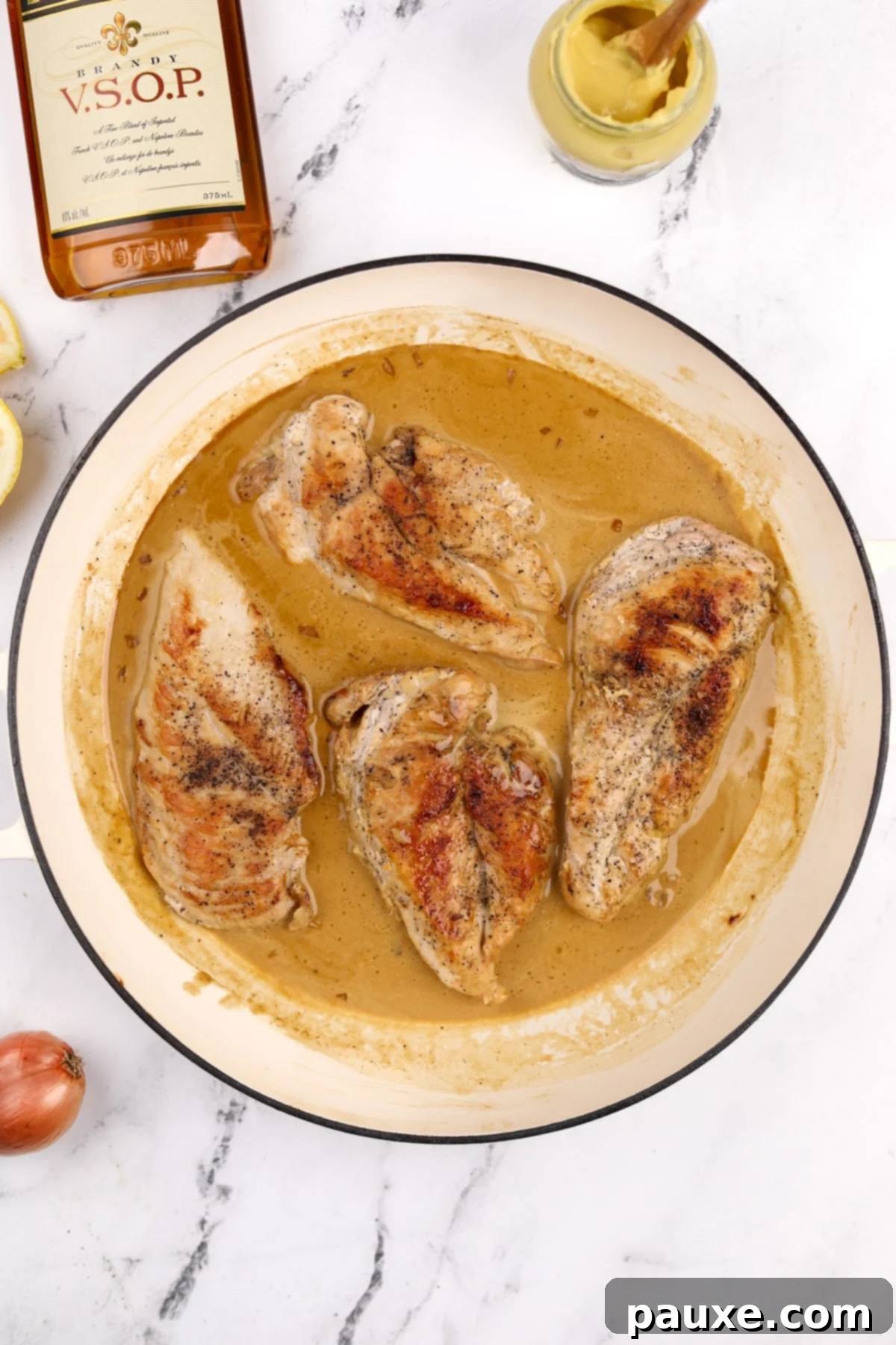 The cooked chicken breasts nestled back into the rich, creamy Diane sauce in the skillet, ready for final garnishing.