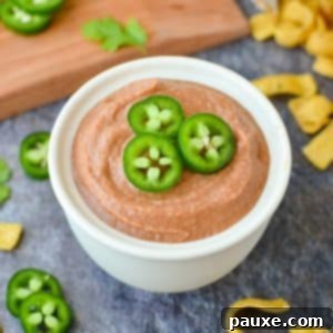 Craveable Homemade Fritos Bean Dip 9 A bowl of bean dip garnished with sliced jalapeños.