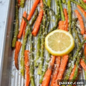 Garlic Herb Roasted Asparagus and Carrots 8 A sheet pan with roasted carrots and asparagus, garnished with lemon slices, from a recipe card.