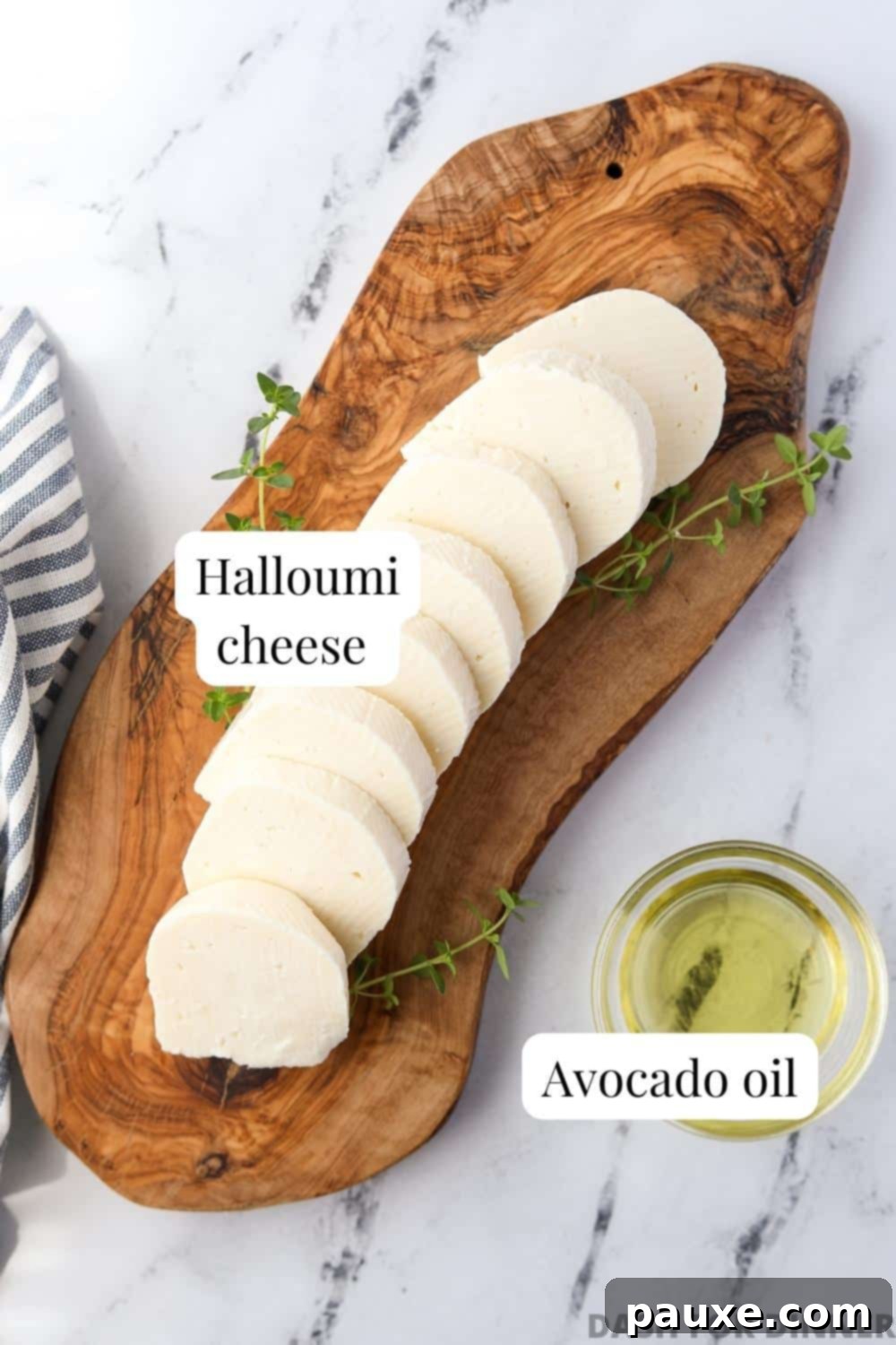 Golden Air Fryer Halloumi 3 A wooden board showcasing a block of Halloumi cheese, sliced pieces, and a small bowl of avocado oil, ready for air frying.