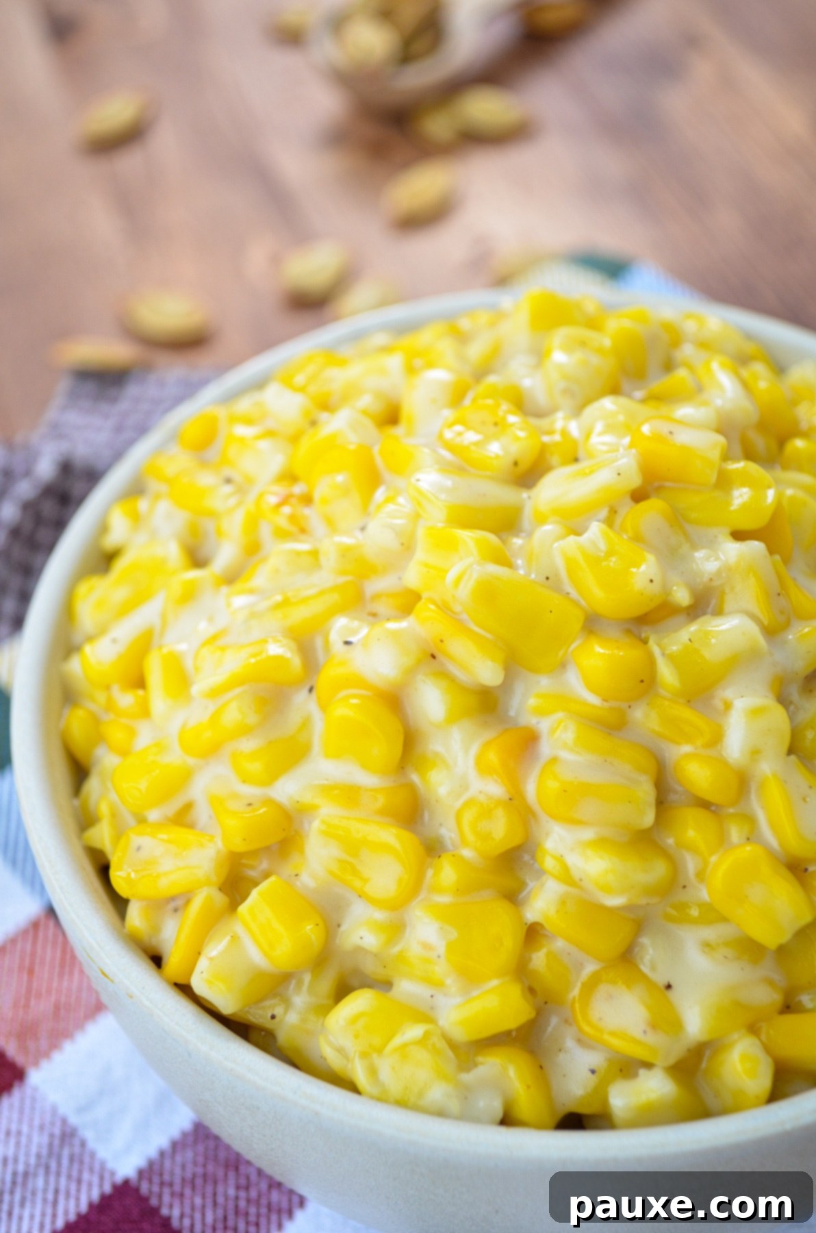 A bowl of creamed corn, resting on colorful napkins.
