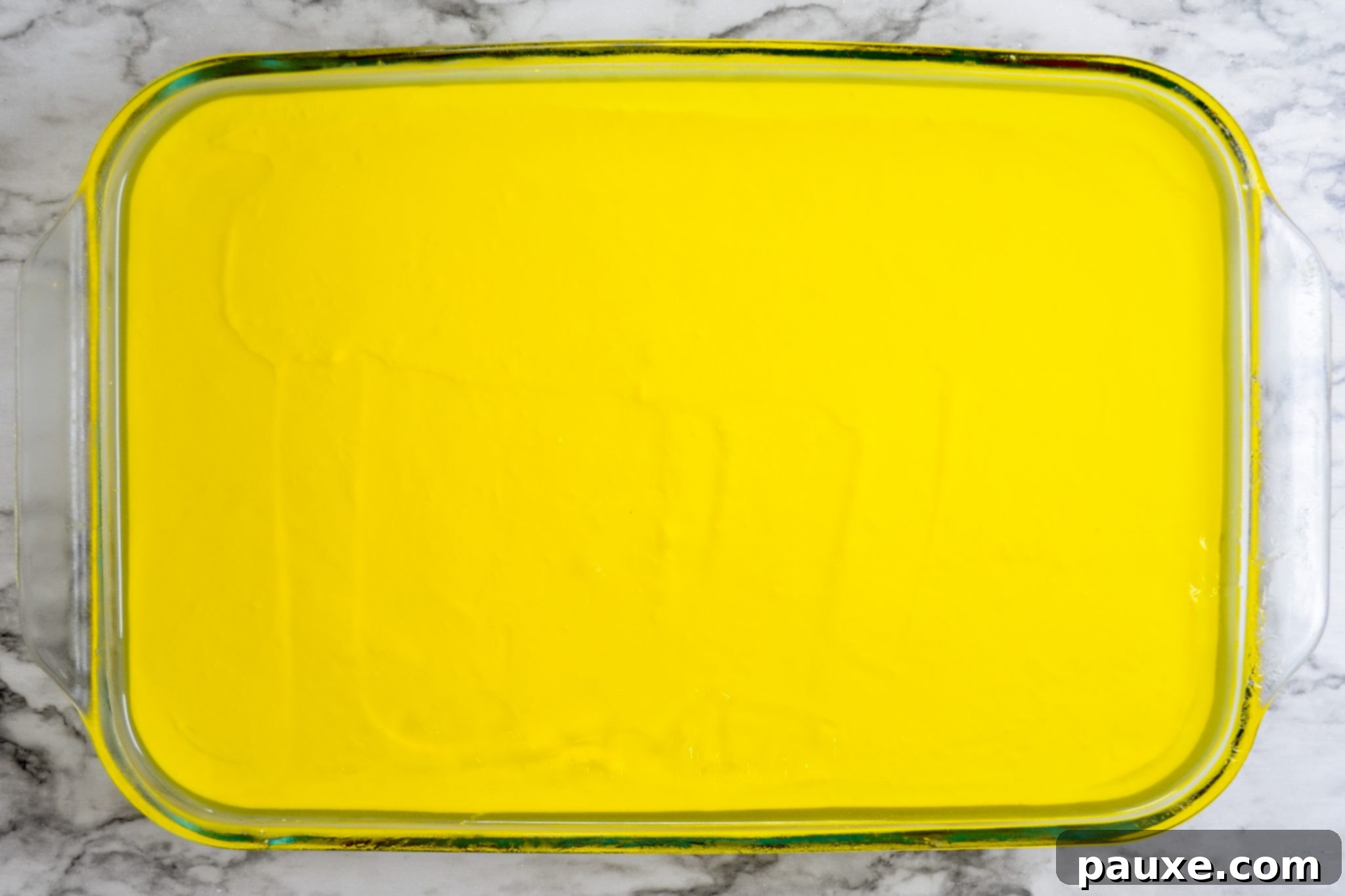 Spooky Layered Gelatin 11 The final lemon Jell-O layer being gently poured over the creamy layer in the Halloween Jell-O dessert.