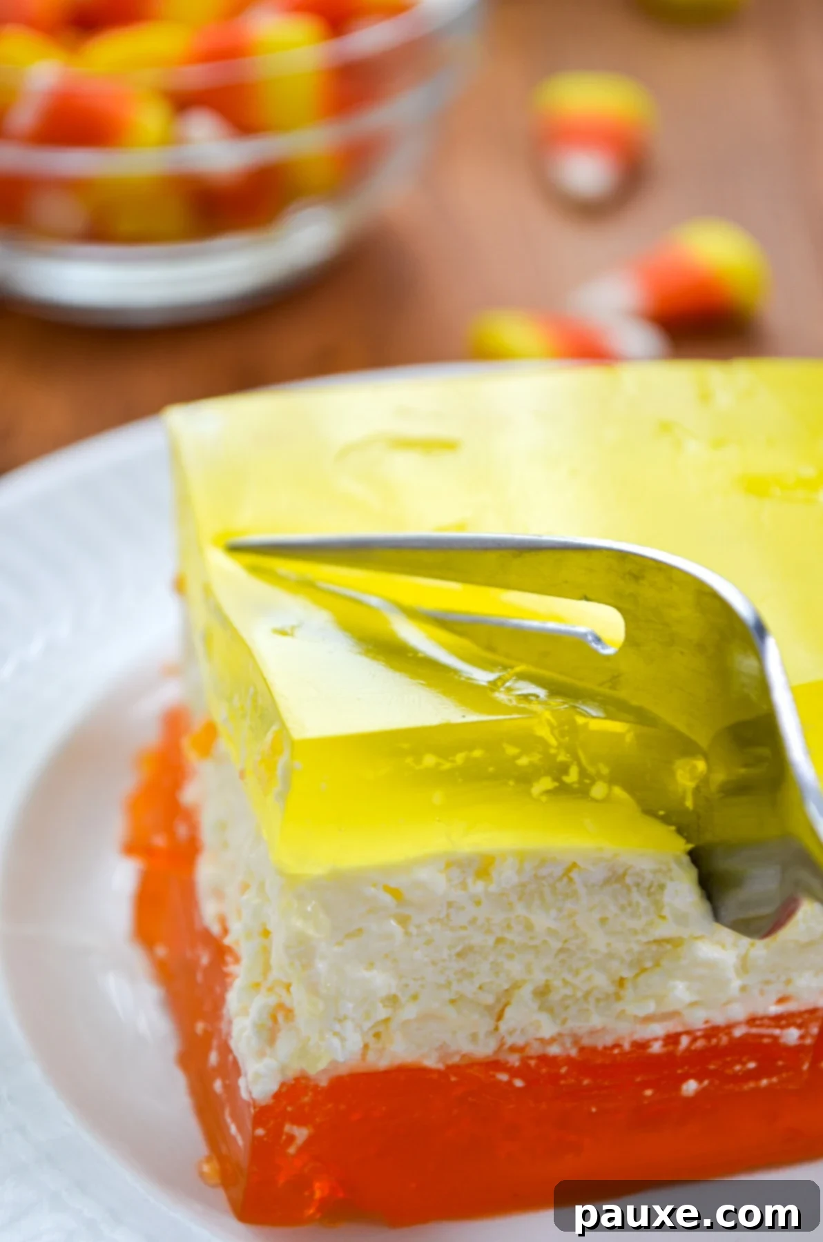 Spooky Layered Gelatin 12 A piece of Halloween-inspired layered jello being lifted from the dish with a fork, showing all three layers.