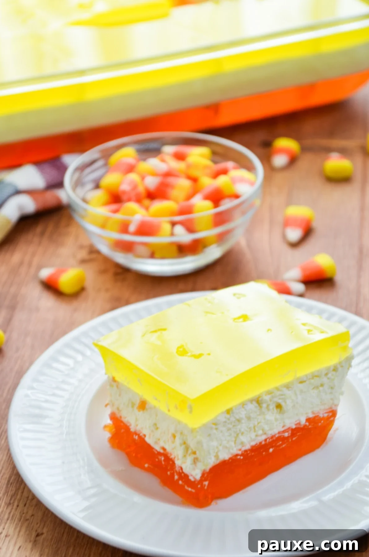 Spooky Layered Gelatin 13 A beautiful slice of 3-layered Halloween Jello, with candy corns artfully scattered in the background.