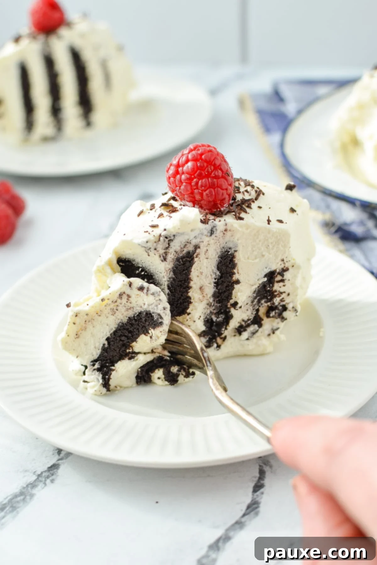 No-Bake Chocolate Wafer Zebra Delight 9 A fork taking a delicious portion from a slice of Chocolate Wafer Icebox Cake, highlighting its moist and tender texture.