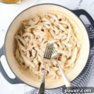 Ultimate Dutch Oven Pulled Chicken 11 A Dutch Oven with two forks and perfectly shredded chicken.