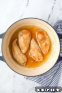 Ultimate Dutch Oven Pulled Chicken 14 Cooked chicken breasts in a poaching liquid.