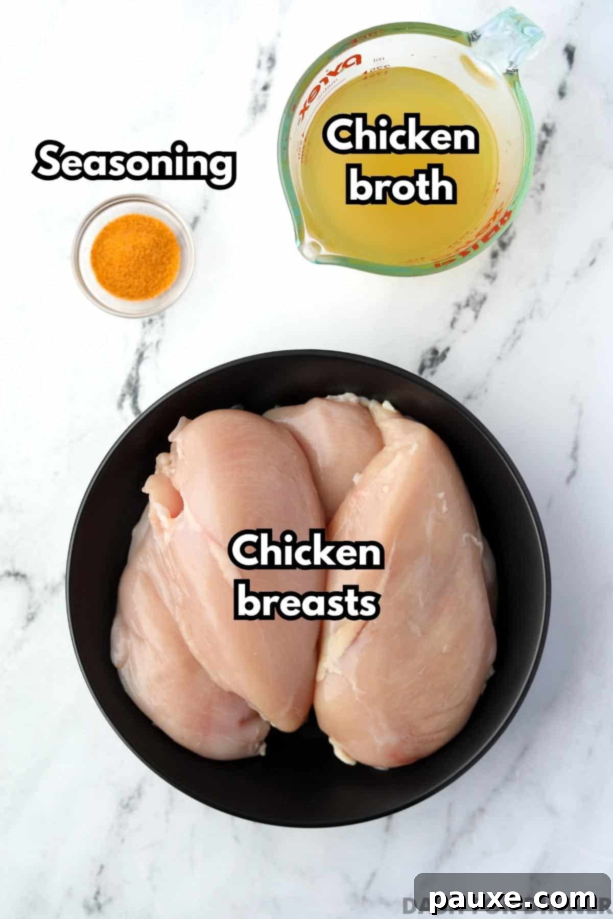 Ultimate Dutch Oven Pulled Chicken 3 A plate with four raw chicken breasts, a small measuring cup of chicken broth, and a sprinkle of seasoned salt, ready for preparation.