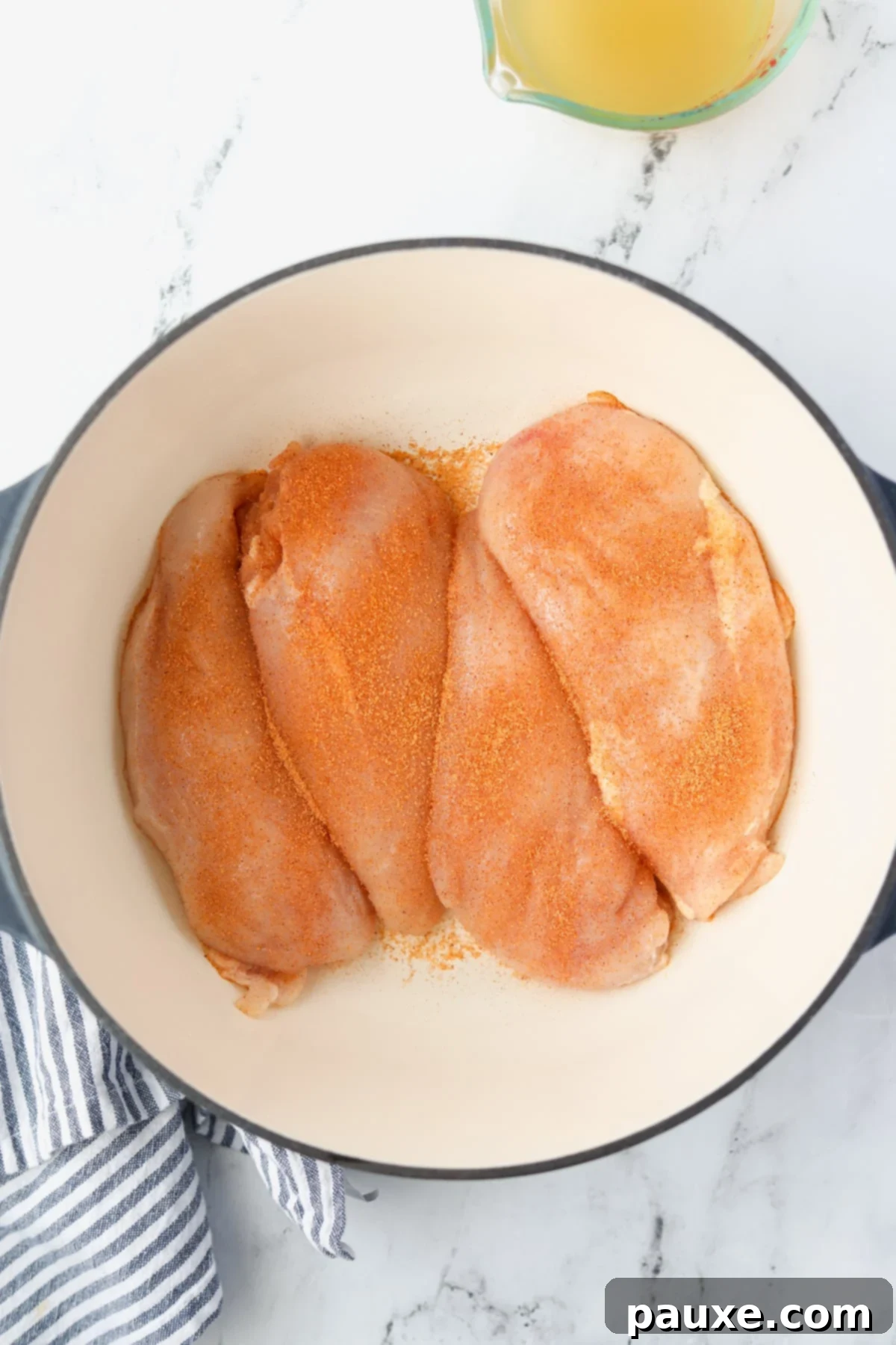 Ultimate Dutch Oven Pulled Chicken 5 A Dutch Oven with four raw chicken breasts generously seasoned with salt and spices.