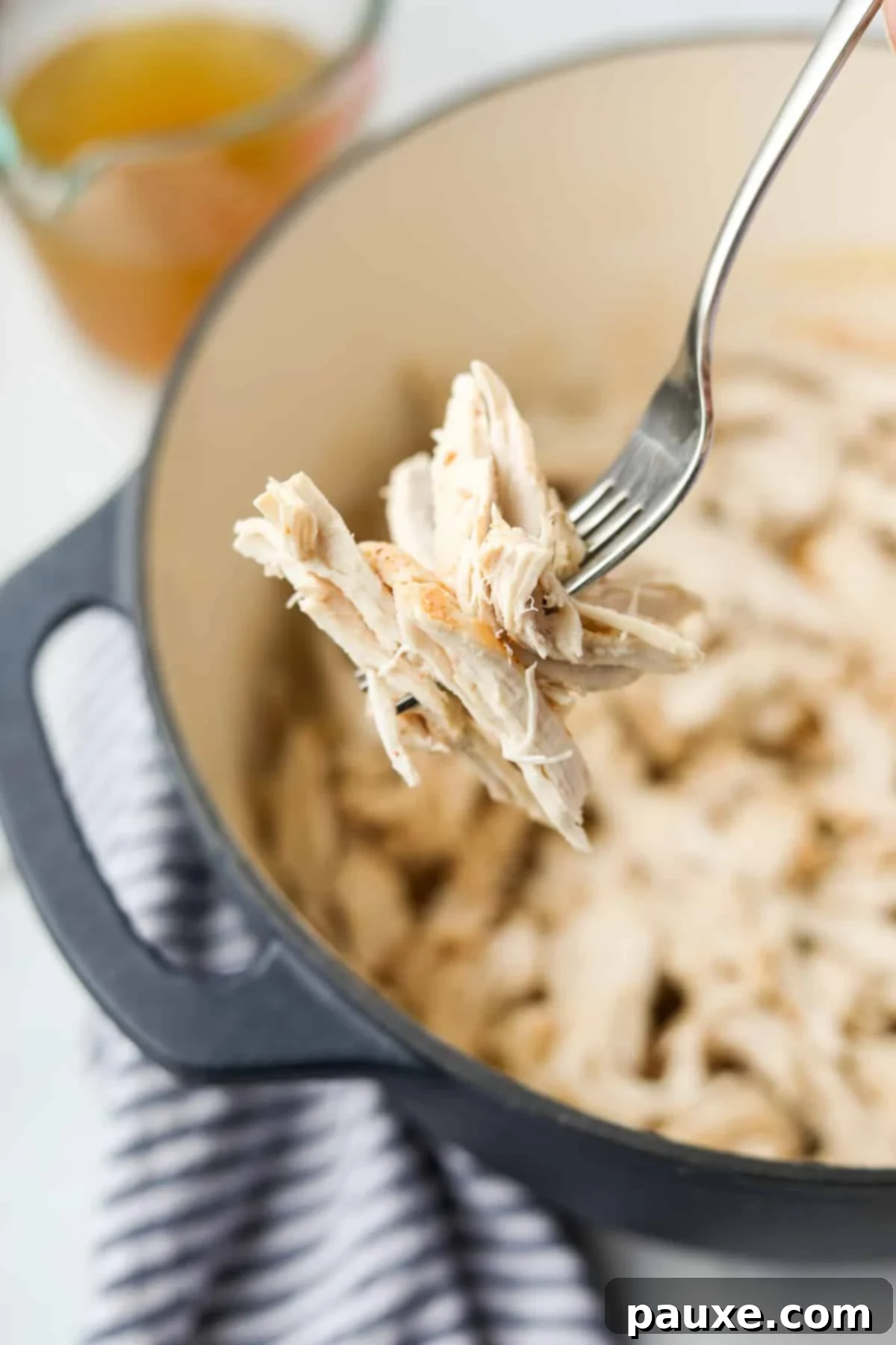 Ultimate Dutch Oven Pulled Chicken 9 A fork holding a perfect bite of juicy shredded chicken, demonstrating its tender texture.