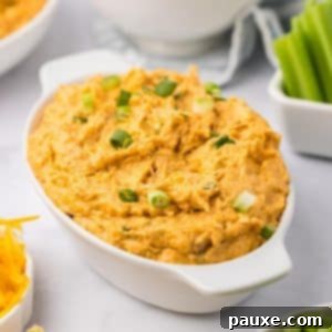 Zesty Slow Cooker Buffalo Chicken Dip 16 Buffalo chicken dip served hot in an oval baking dish, ready for dipping.