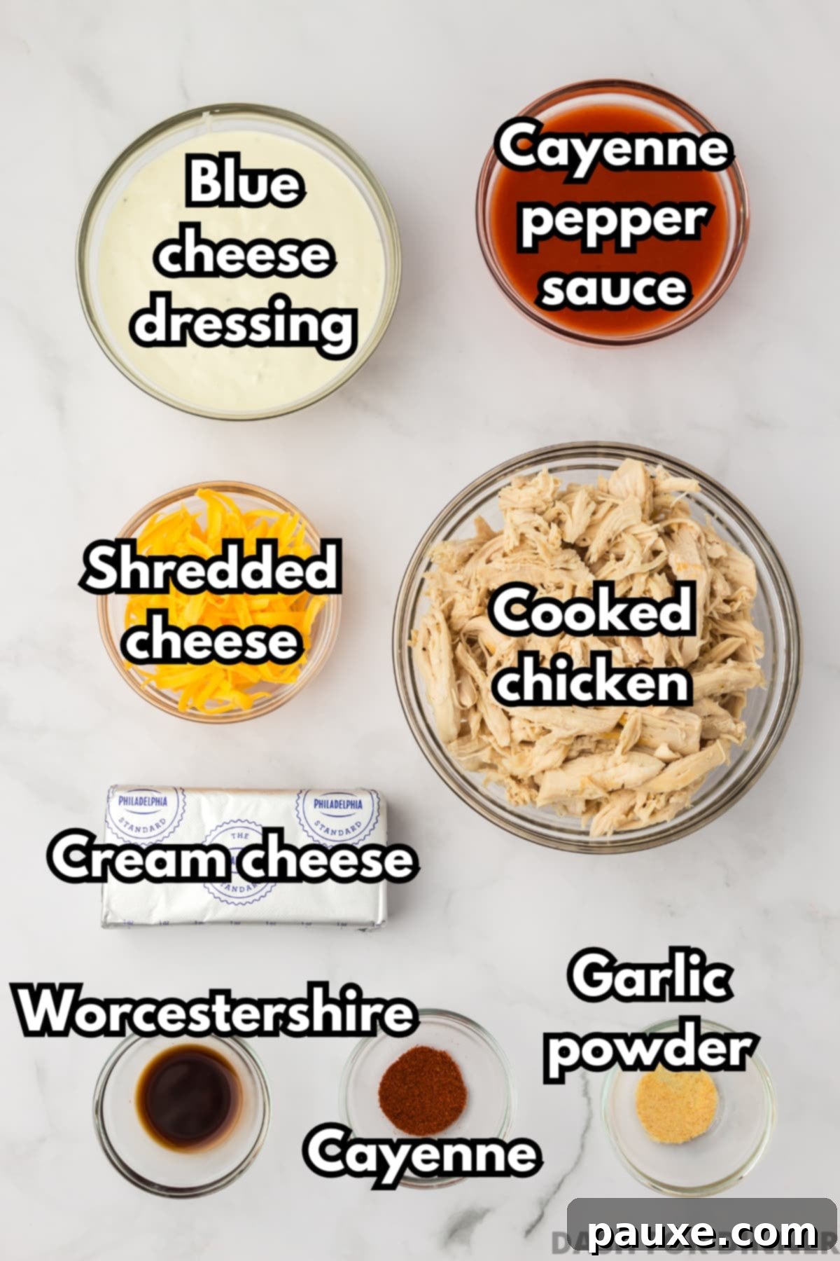 Zesty Slow Cooker Buffalo Chicken Dip 3 The ingredients needed to make buffalo chicken dip, including cayenne pepper sauce, blue cheese dressing, cream cheese, cheddar cheese, and cooked chicken arranged neatly.