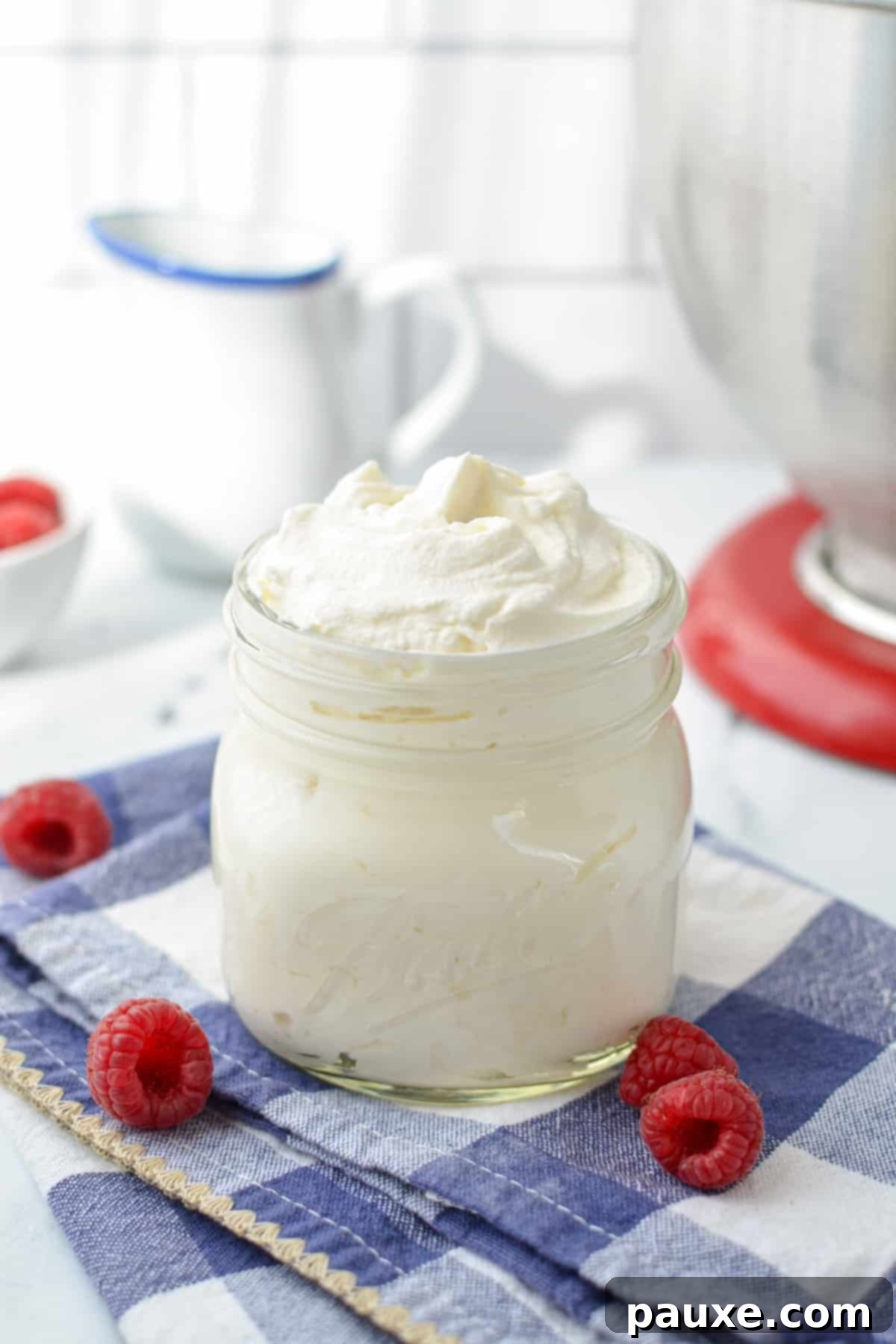 A jar of whipped cream, surrounded by fresh berries.