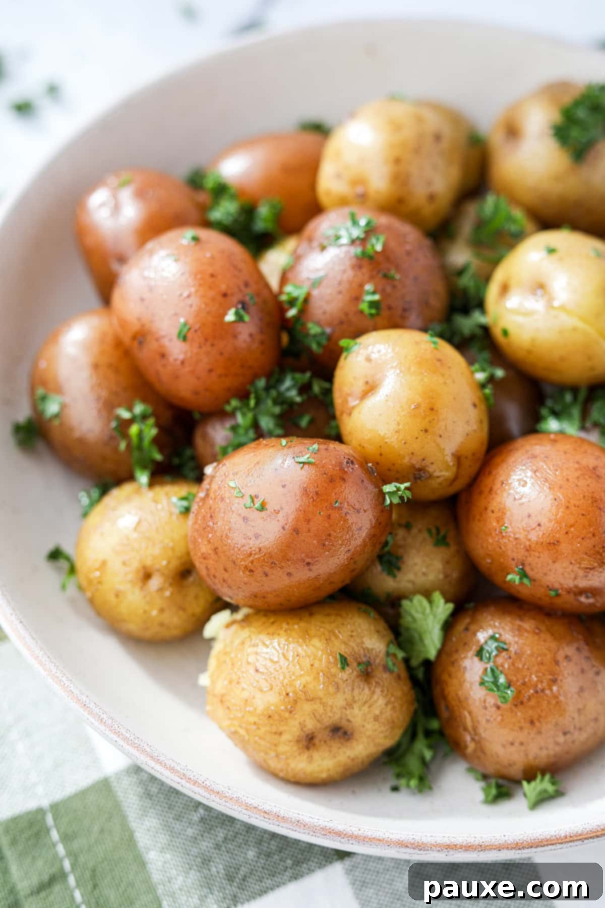 Perfect Instant Pot Baby Potatoes 2 A vibrant bowl of steamed small baby potatoes, seasoned with fresh parsley and a hint of butter, ready to be served as a side dish.