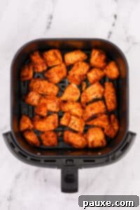 Air-Fried Salmon Nuggets 16 An air fryer basket filled with cooked salmon pieces.