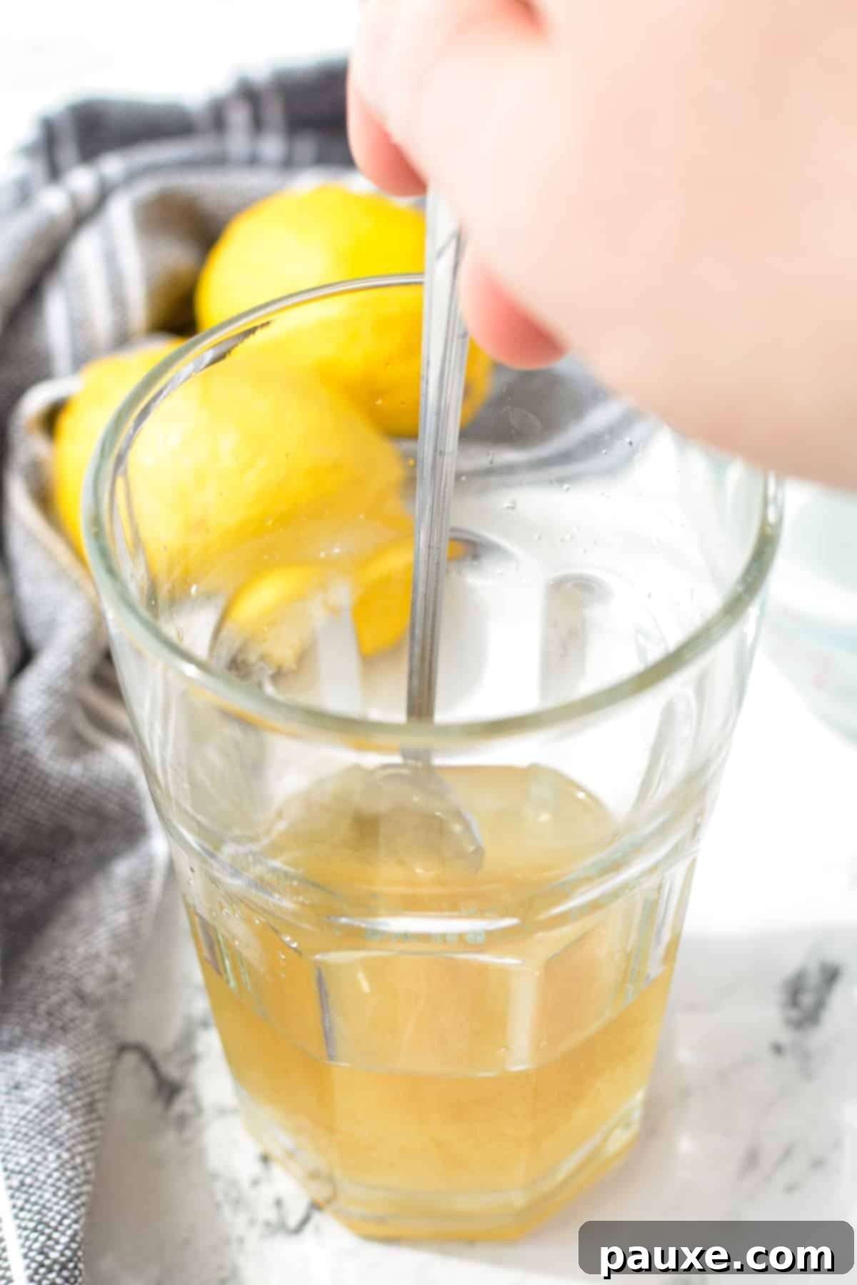 Solo Lemonade Delight 4 Stirring a glass with a long spoon.