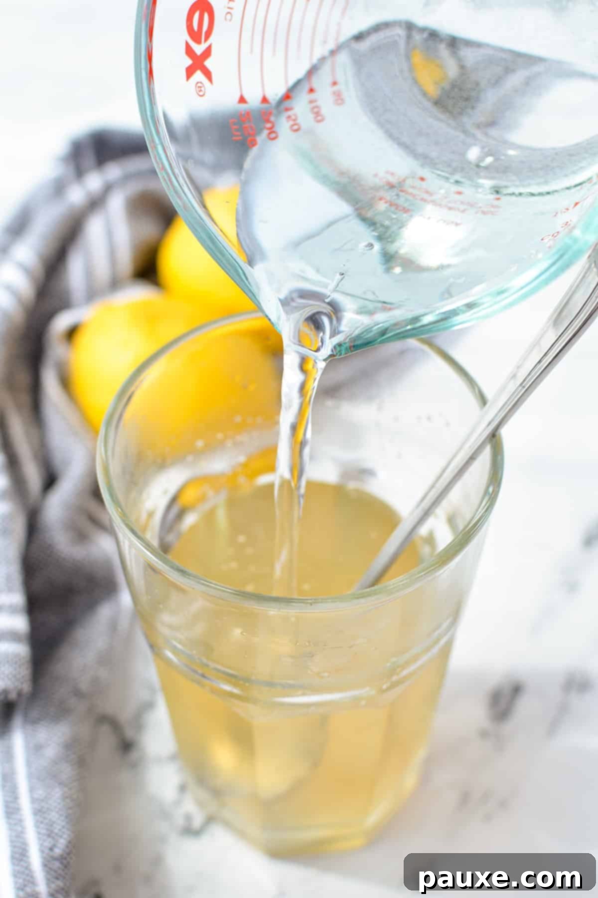 Solo Lemonade Delight 5 Pouring water into a glass with liquid in it.
