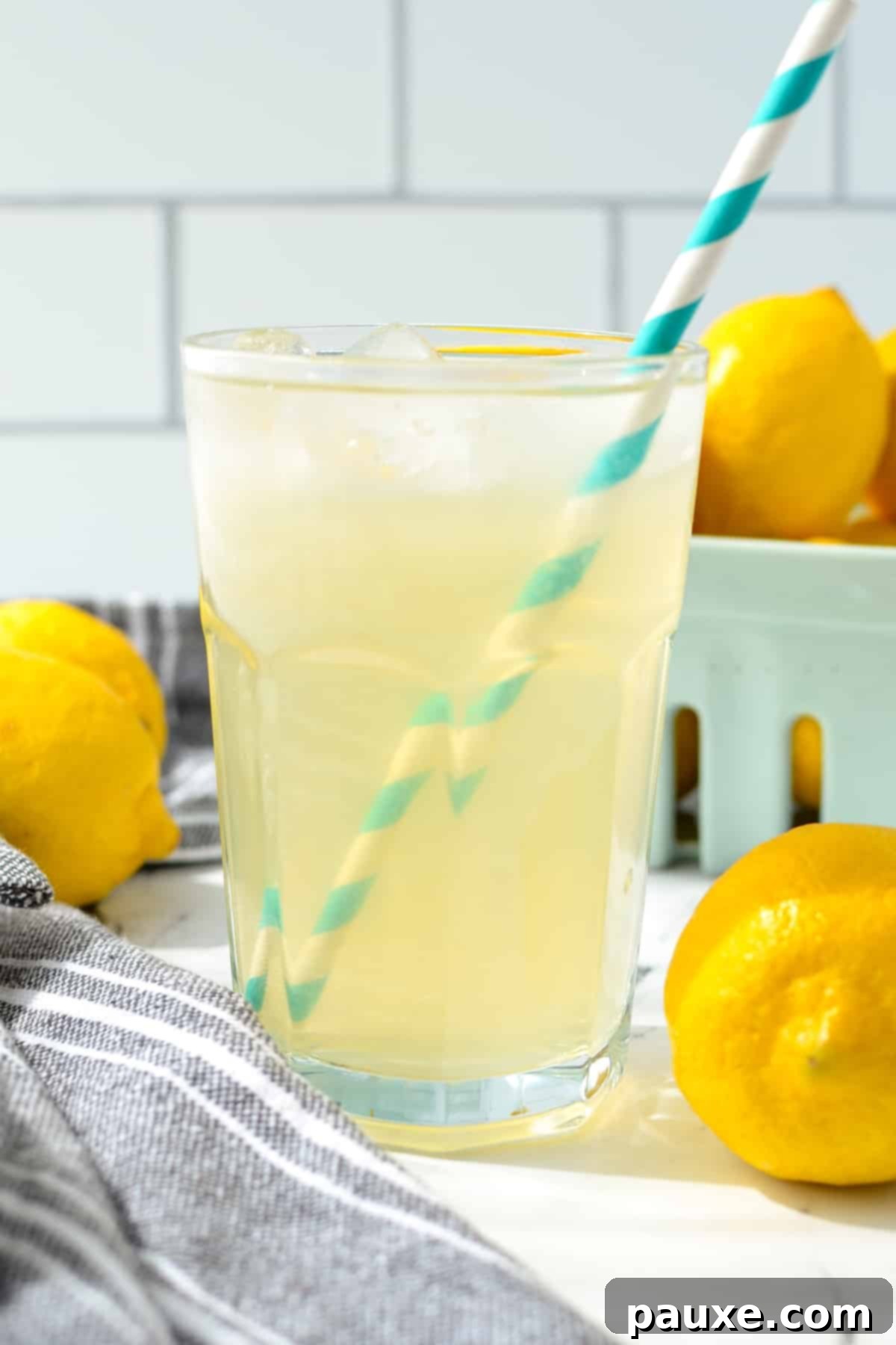 Solo Lemonade Delight 9 A glass of lemonade with multiple fresh lemons in the background.