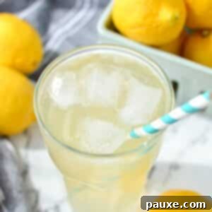 Solo Lemonade Delight 10 A glass of lemonade wiht a paper straw inserted into the glass.