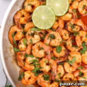 Zesty Cilantro Lime Shrimp 8 A skillet filled with cooked shrimp and garnished with fresh cilantro and lime slices, a perfect quick meal.