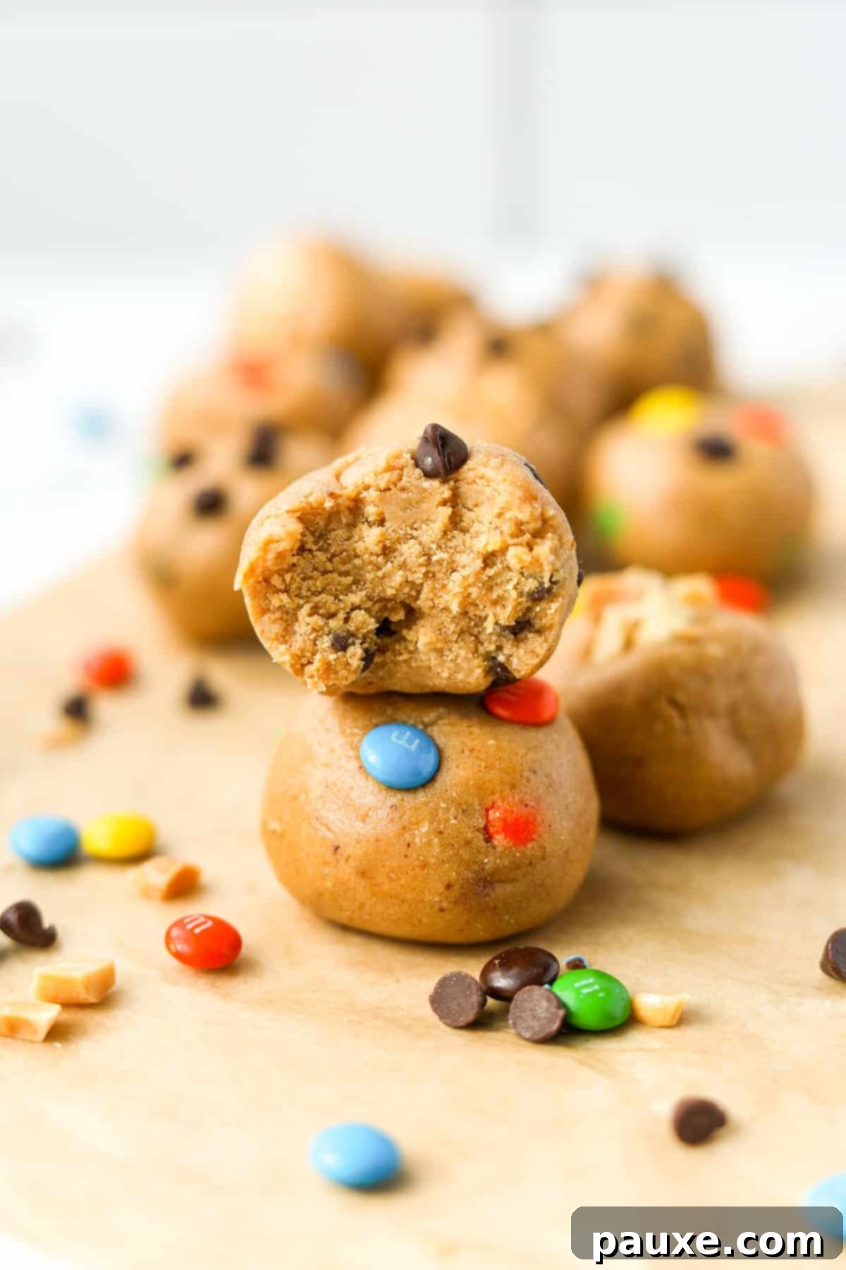 Protein-Packed Cookie Dough Bites 2 A stack of two protein balls with m&m's and chocolate chips, showcasing the delicious texture.