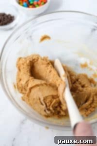 Protein-Packed Cookie Dough Bites 15 Mixing together a protein cookie dough in a bowl.