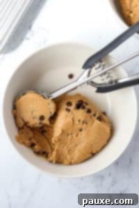 Protein-Packed Cookie Dough Bites 17 A bowl with protein cookie dough being scooped by a cookie scoop.