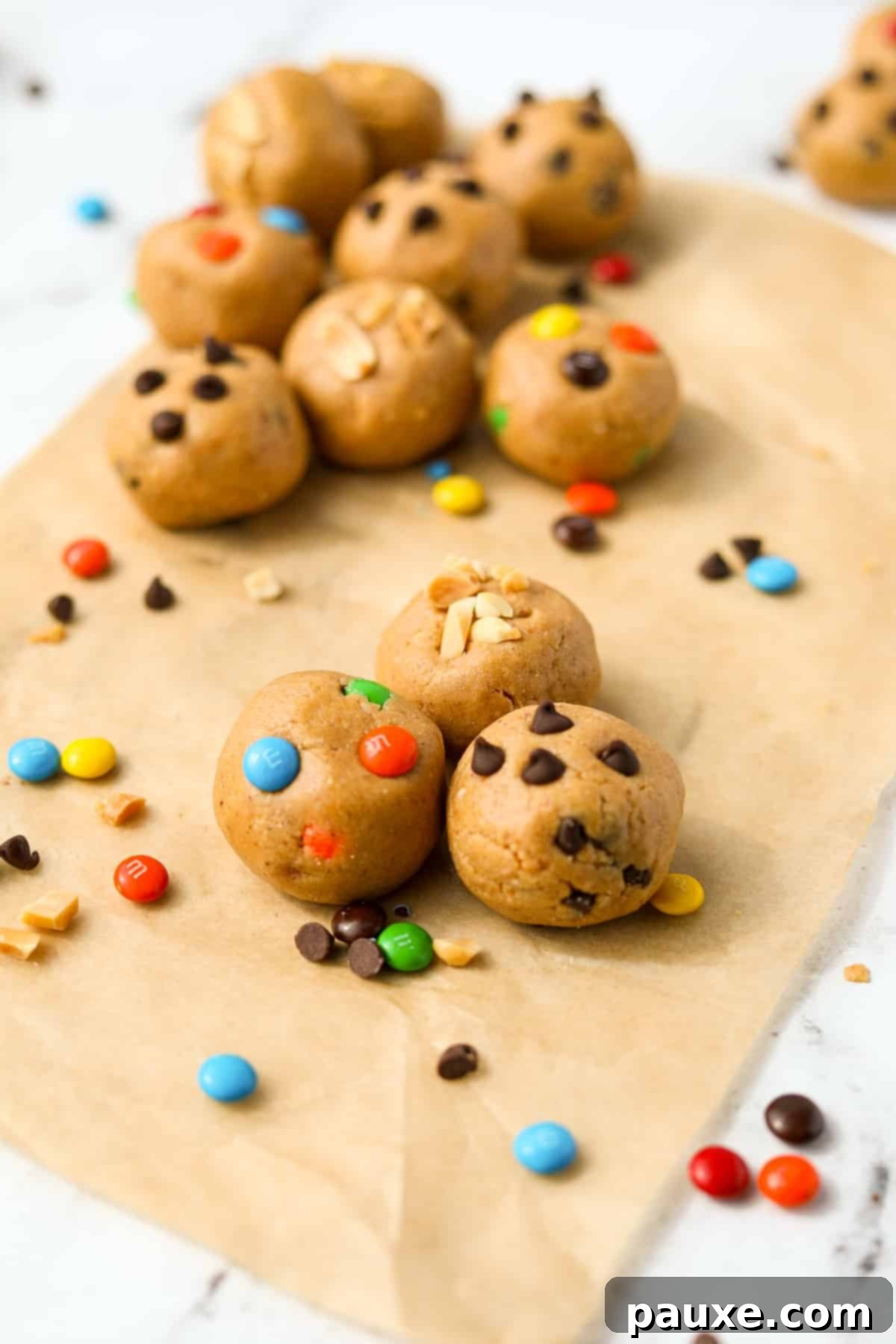 Protein-Packed Cookie Dough Bites 4 Three protein cookie dough balls in the center, with others arranged around them, highlighting their appealing texture and mix-ins.