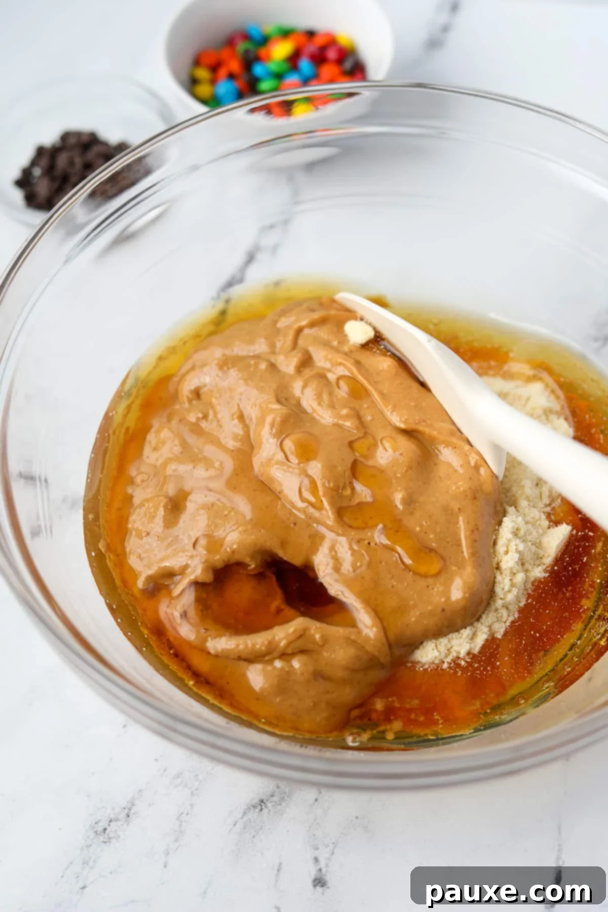 Protein-Packed Cookie Dough Bites 5 Stirring together a protein cookie dough in a large bowl with a silicone spatula.