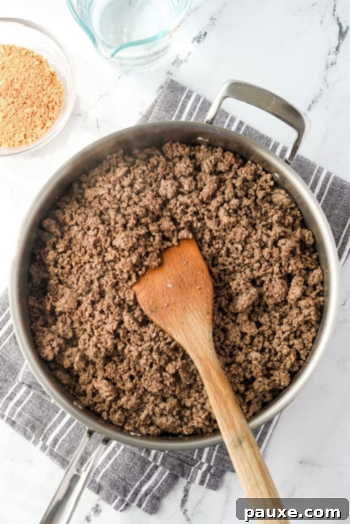 Ground beef browning in a large skillet over medium heat.