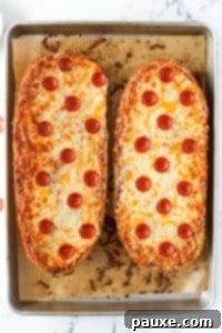 Speedy French Bread Pizzas 18 Two halves of French Bread pizza on a baking sheet.