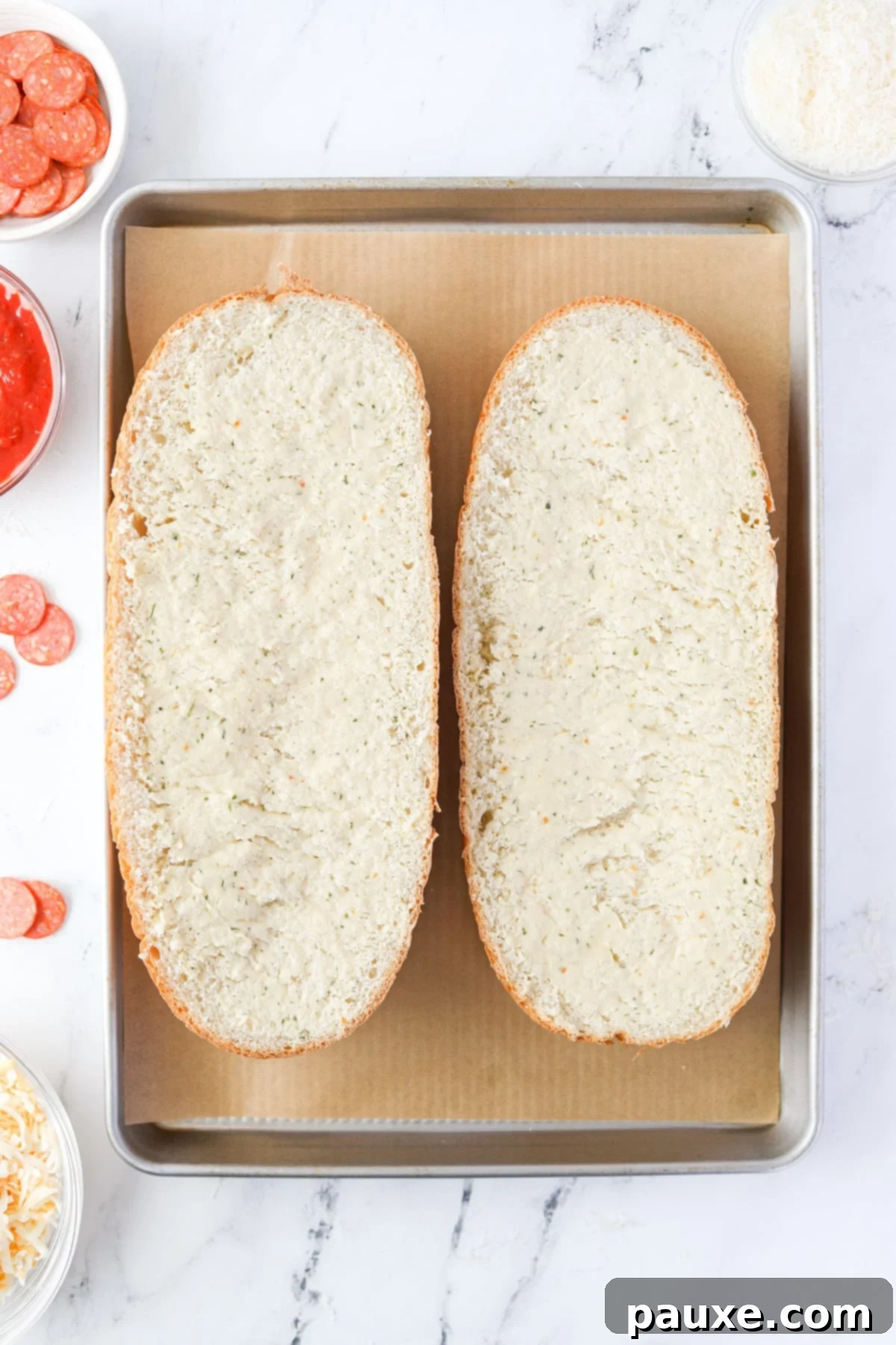 Speedy French Bread Pizzas 4 Two halves of a French Loaf on a baking pan.
